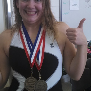 ALLISON SHOWING OFF HER SWIMMING MEDALS.